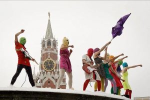 Pussy Riot waving flags in front of steeple
